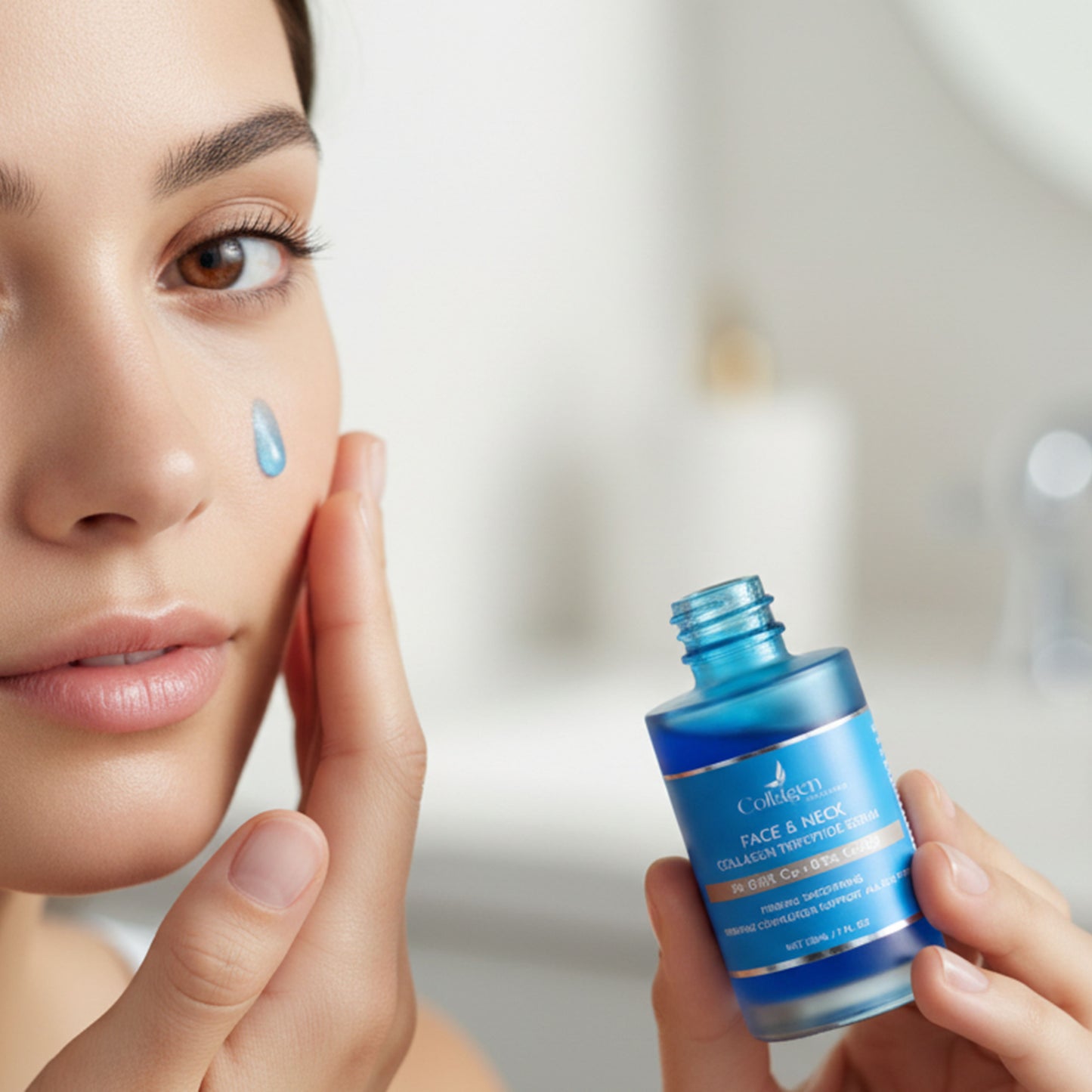Woman applying a blue skincare serum to her face with a blurred background